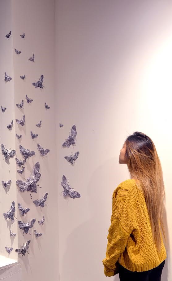 Ashcan student with her moth installation at the annual student exhibition at Gallery Madison Park
